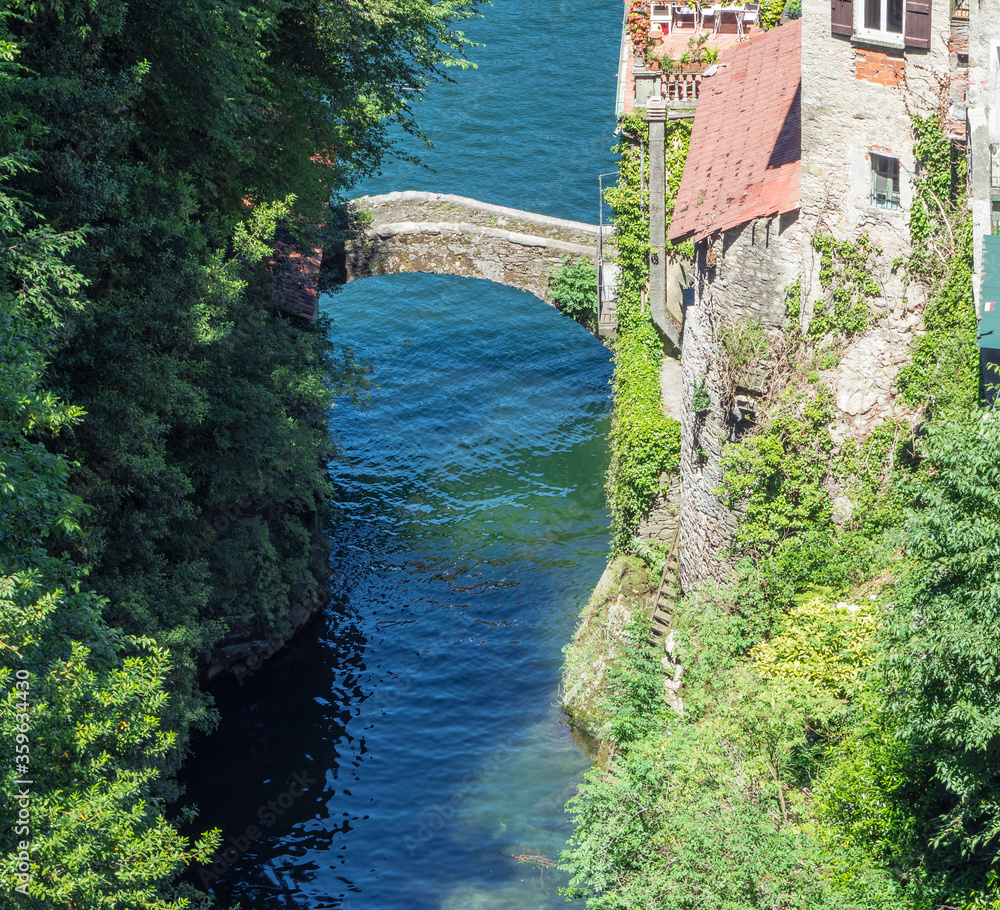 medieval stone arch bridge. Nesso - Italy, tourist resort of Como Lake.