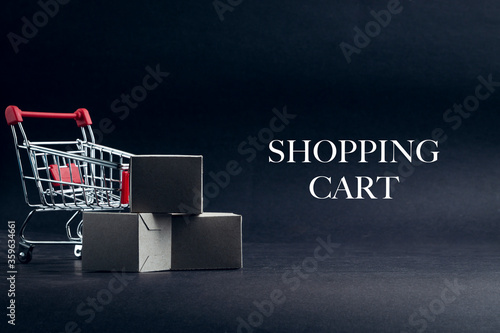 SHOPPING CART text with shopping cart on dark background. Business, Copy space and online shopping concept. Selective focus