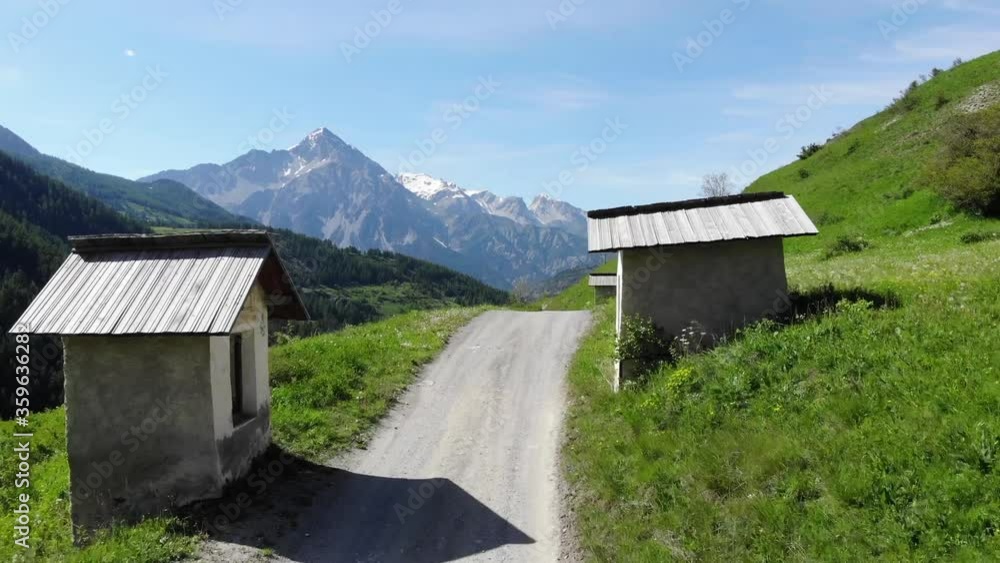 aerial passage between two little chapels on a high mountain path, summer aerial passage between two little chapels on a high mountain path, summer