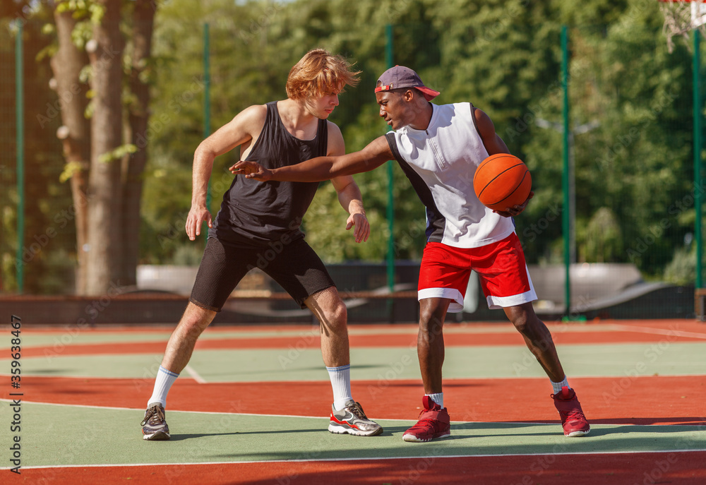 Professional basketball players on outdoor court during friendly game