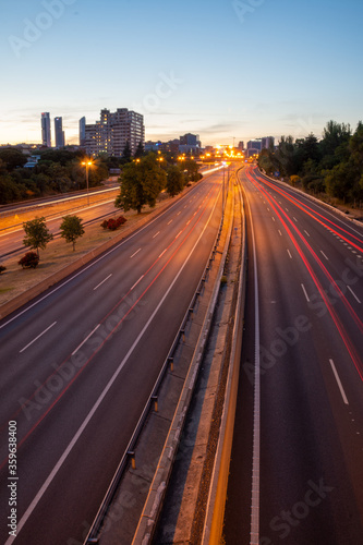 Panoramic urban view of M30 at sunset with red trails of cars in Madrid, Spain, vertically