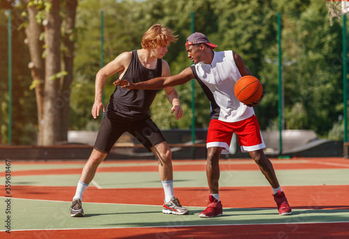 Professional basketball players on outdoor court during friendly game