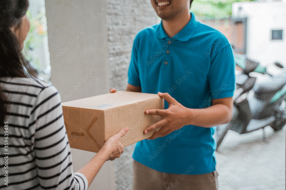 courier delivering package box to woman at home courier delivering package box to woman at home