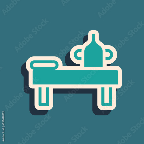 Green Massage table with oil icon isolated on green background. Long shadow style. Vector.