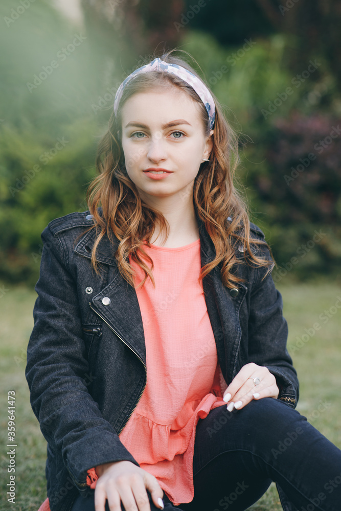 Obraz premium Attractive young woman enjoying her time outside in park with sunset in background