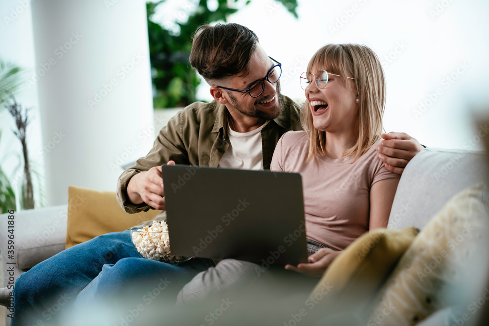 Young couple watching movie on lap top. Loving couple enjoying at home. Young couple watching movie on lap top. Loving couple enjoying at home.