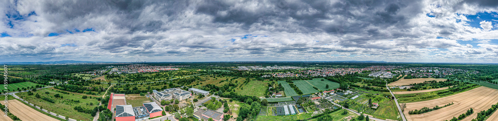 Panoramic drone picture of the city Moerfelden-Walldorf with the skyline of Frankfurt in the background at evening
