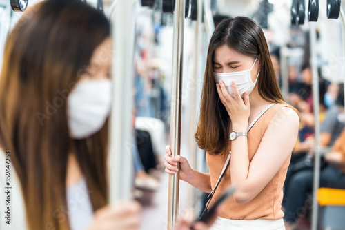 Obraz na płótnie Young Asian woman passenger wearing surgical mask and sneezing in subway train when traveling in big city at Covid19 outbreak, Infection and Pandemic, social distancing and new normal concept w salonie