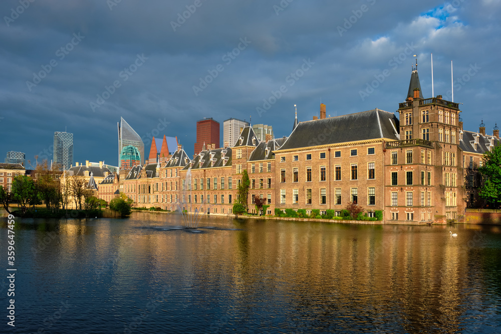 View of the Binnenhof House of Parliament and the Hofvijver lake with downtown skyscrapers in background. The Hague, Netherlands