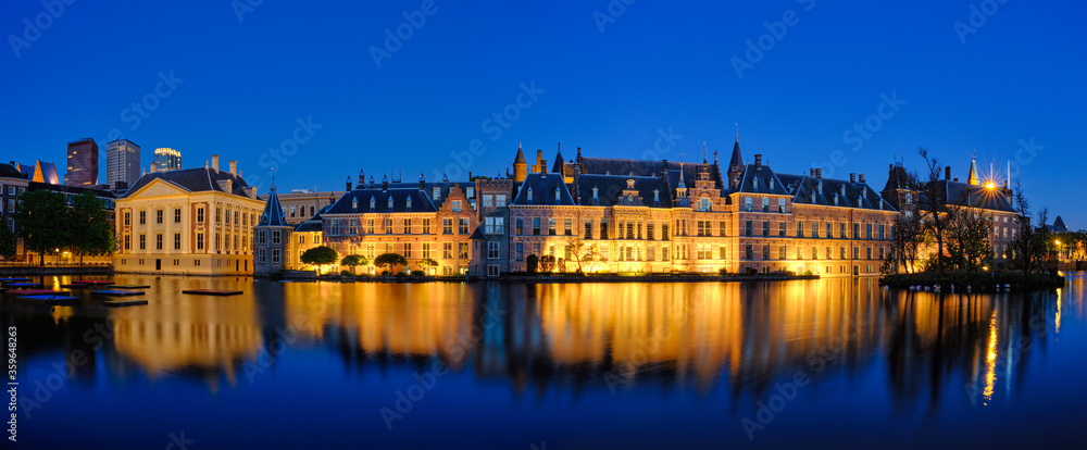 Panorama of the Binnenhof House of Parliament and Mauritshuis museum and the Hofvijver lake illuminated in the night. The Hague, Netherlands