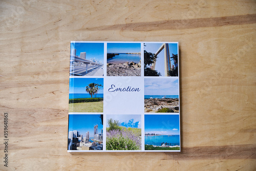 Close-up picture of firm photo book pages on wooden table. Flat lay picture of travel printed album. Photography package. Family memories in pictures. photo