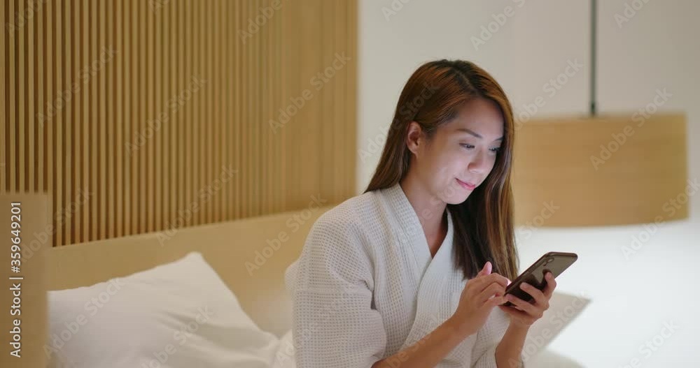 Woman use of mobile phone on bed