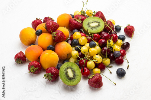 Assorted fresh berries and fruits. Apricots Kiwi Strawberry Cherry Blueberry on white background.