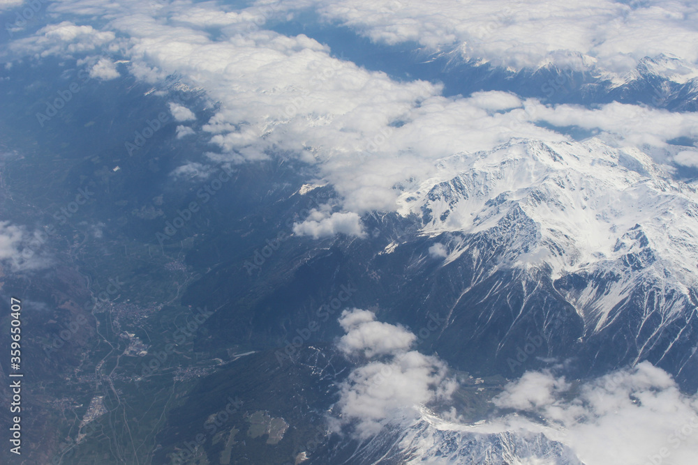 Widok z samolotu na góry Alpejskie. Śnieg na górach gór. Widok na Jezioro i alpejskie miasteczka.