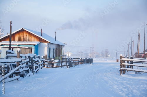 Winter landscape of the village Oymyakon with traditional wooden houses and smoke from the chimneys, one of the coldest permanently inhabited settlements on Earth, Sakha Republic, Russia, -48 °C