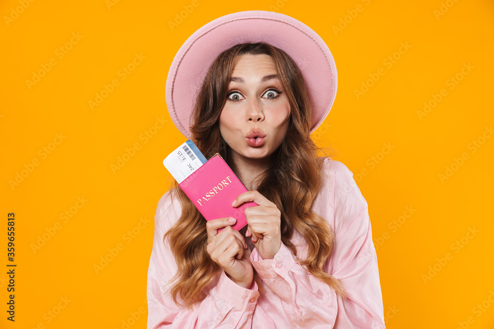 Image of woman holding passport with ticket and making kiss lips Image of woman holding passport with ticket and making kiss lips
