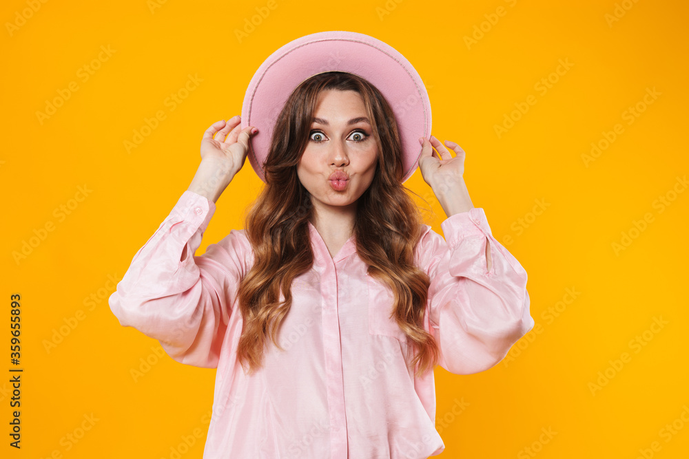 Image of attractive surprised woman in hat making kiss lips on camera Image of attractive surprised woman in hat making kiss lips on camera