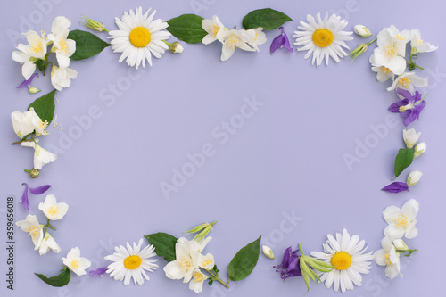Floral composition. Frame made of various colorful flowers on purple background. Easter, spring, summer concept. Flat lay, top view, copy space for text.
