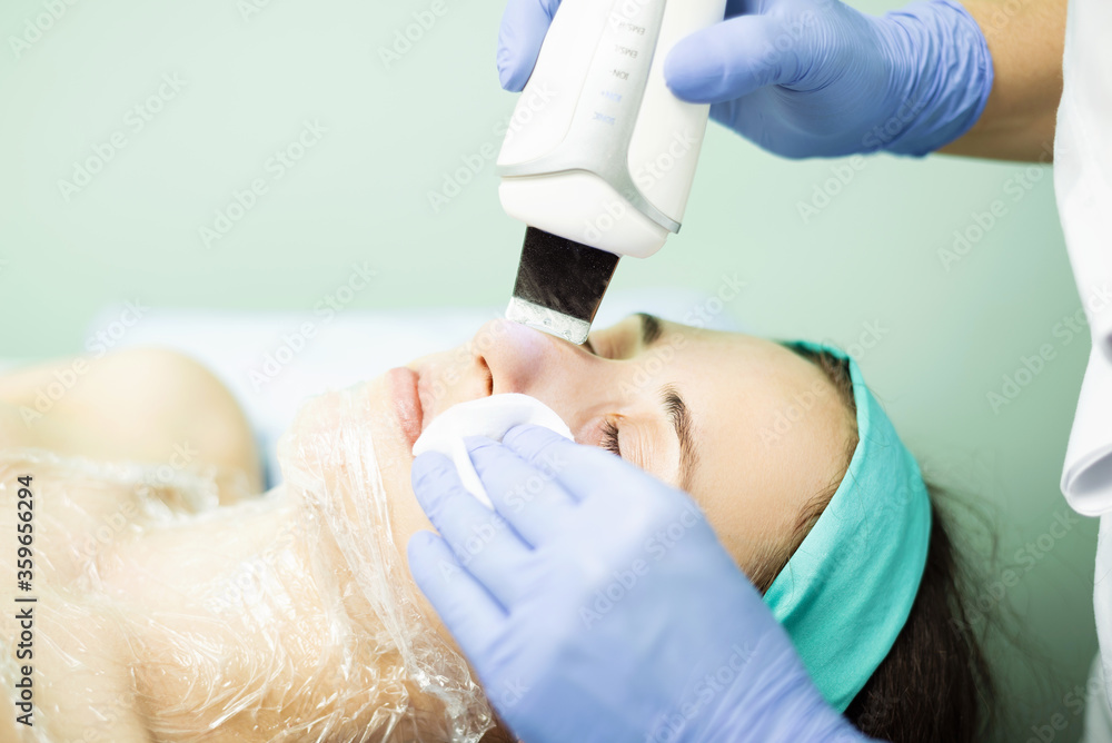 Naklejka premium Photo of woman cleaning facial skin with ultrasonic device, health and beauty concept.