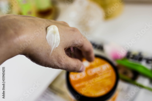 Woman moisturizing her hand with cosmetic cream. Close up view.