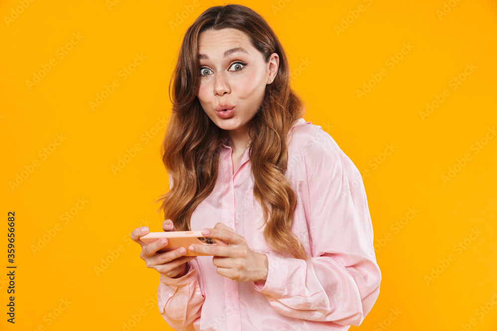Image of woman making kiss lips and playing video game on cellphone Image of woman making kiss lips and playing video game on cellphone
