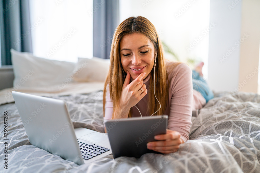Happy woman using laptop, tablet, computer at home Happy woman using laptop, tablet, computer at home