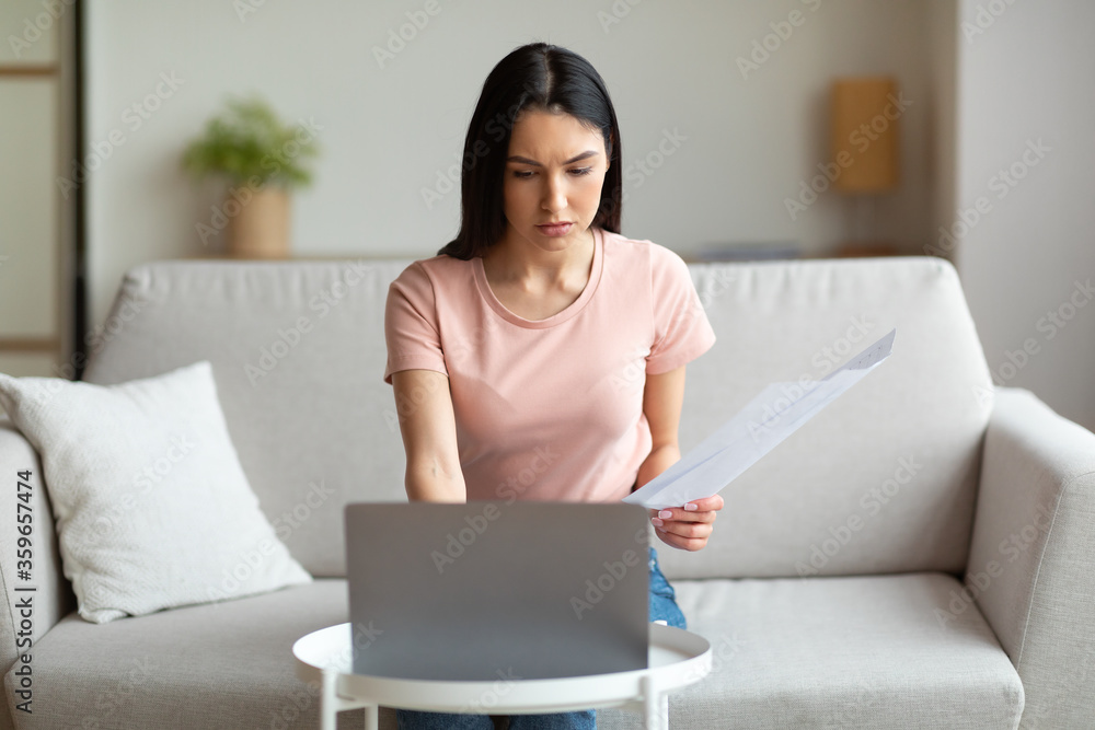 Serious Freelancer Girl Working On Laptop Sitting On Couch Indoor - obrazy, fototapety, plakaty 