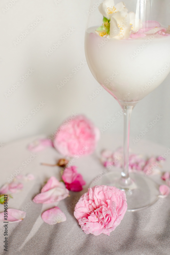 Glass with milk and roses on the table Glass with milk and roses on the table