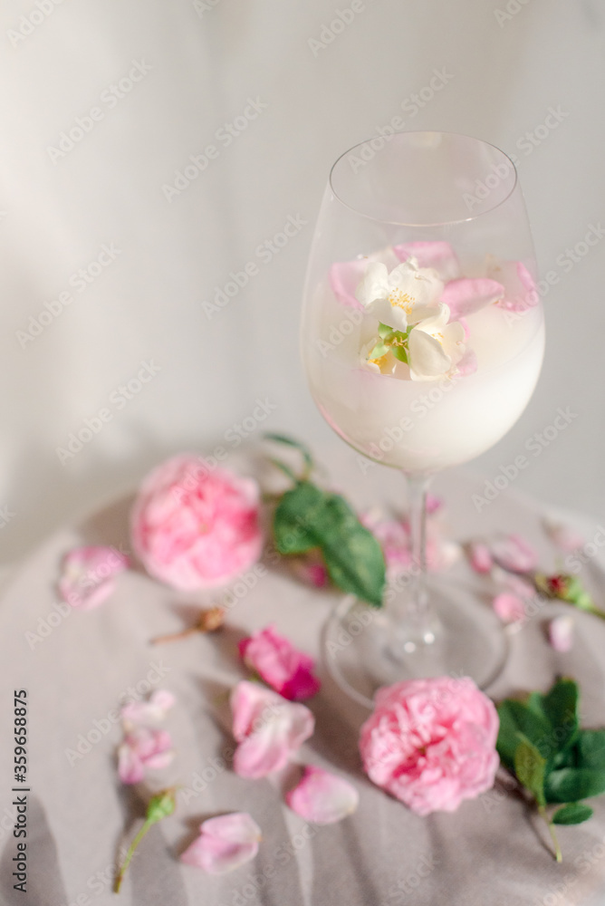 Glass with milk and roses on the table Glass with milk and roses on the table