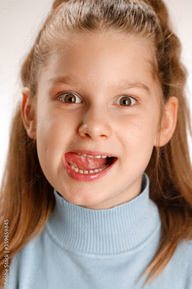 Portrait of a little child licking her lips and teeth. Selective focus Portrait of a little child licking her lips and teeth. Selective focus