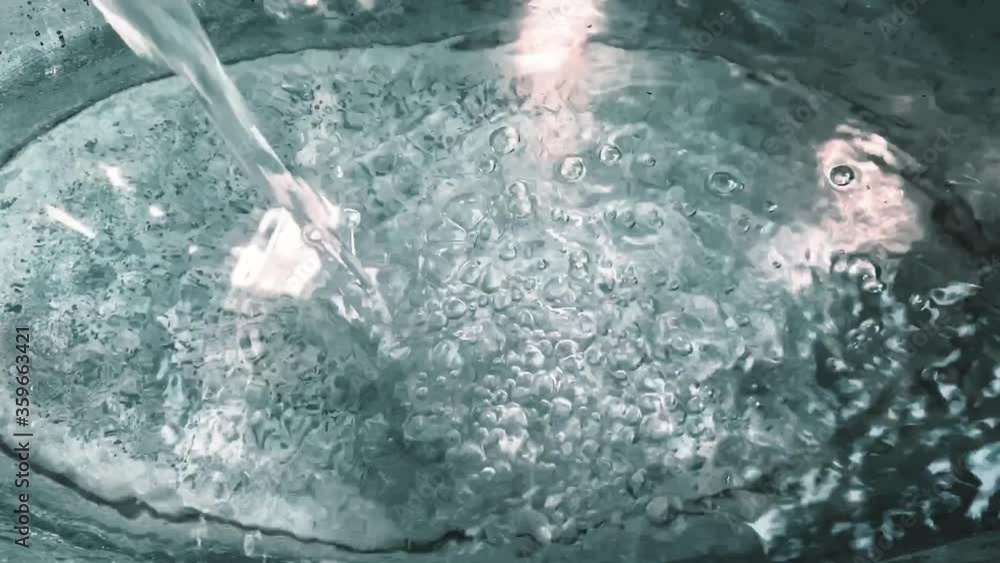 Pouring fresh pure water in washbasin. Slow motion top view of glimmering water Pouring fresh pure water in washbasin. Slow motion top view of glimmering water