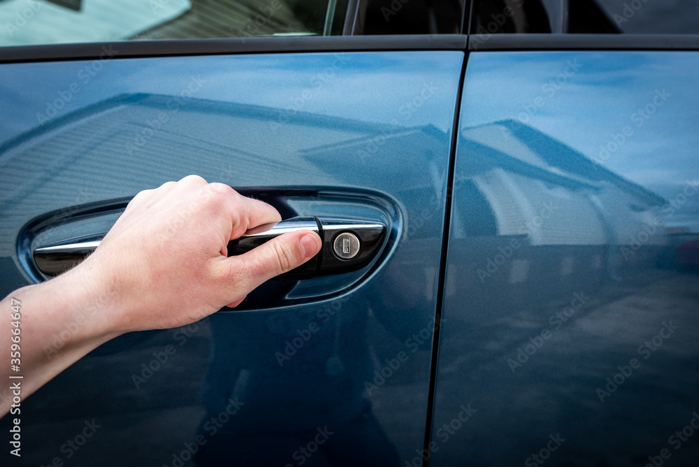 Women hand opening the car door. Women hand opening the car door.