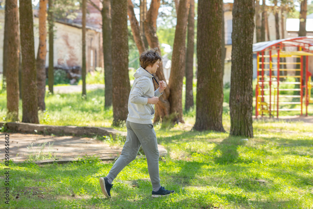 Single young man running in the forest park, street workout. Fitness outside. Exercising alone for Covid-19 revention Single young man running in the forest park, street workout. Fitness outside. Exercising alone for Covid-19 revention