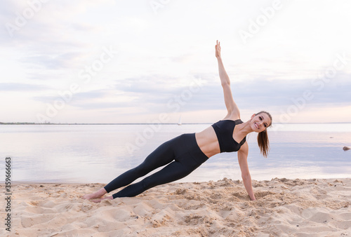  young athletic girl doing fitness yoga by the sea