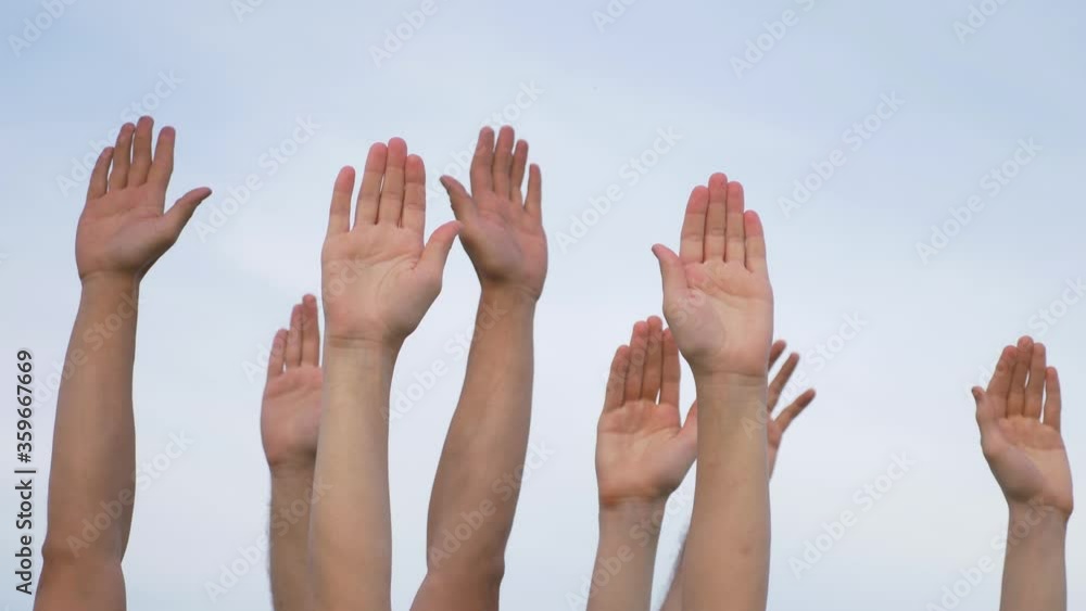 Teamwork. A group of people against the sky raises their hands up. The concept of voluntary voting, expression of consent, support for democracy. Teamwork. A group of people against the sky raises their hands up. The concept of voluntary voting, expression of consent, support for democracy.