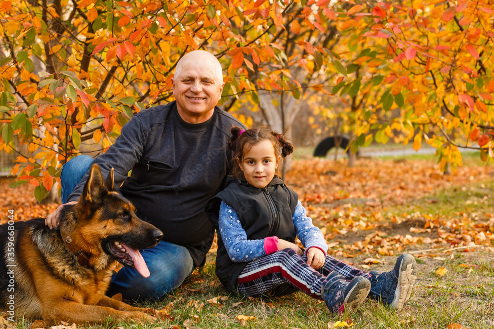 Grandfather with granddaughter and dog, yellow leafs, autumn Grandfather with granddaughter and dog, yellow leafs, autumn