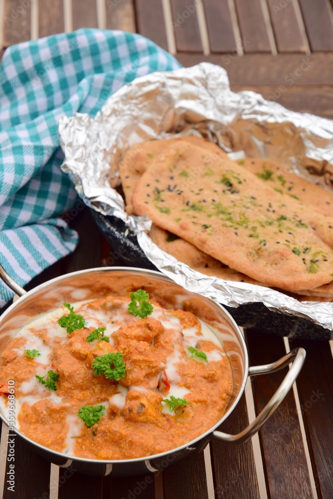 Murgh Makhani or butter chicken served with homemade whole wheat garlic Naan bread Murgh Makhani or butter chicken served with homemade whole wheat garlic Naan bread