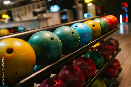 Multicolored bowling balls on the shelf in the bowling club