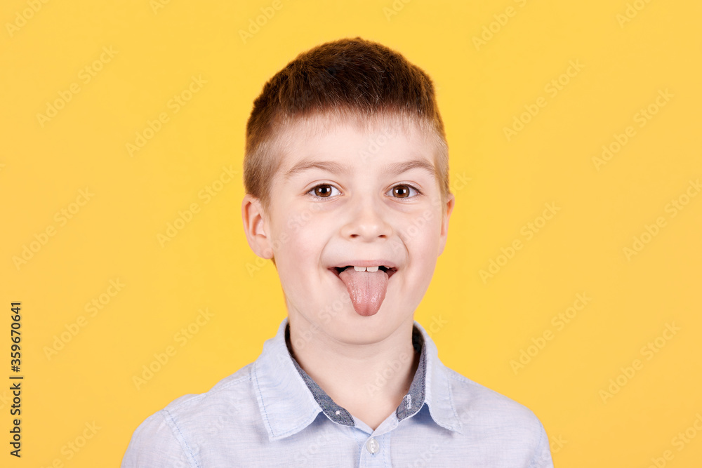 Portrait of a brunette boy, looking at camera, shows tongue. Portrait of a brunette boy, looking at camera, shows tongue.