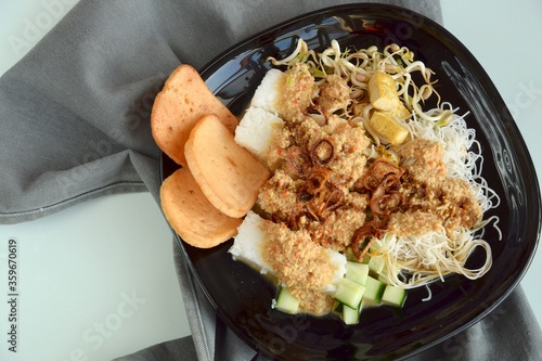 Ketoprak, vegetarian Indonesian food from Indonesia. consists of tofu, cucumber, rice cake, rice vermicelli and mung bean sprouts served with peanut sauce, soy sauce, kerupuk and fried shallot photo