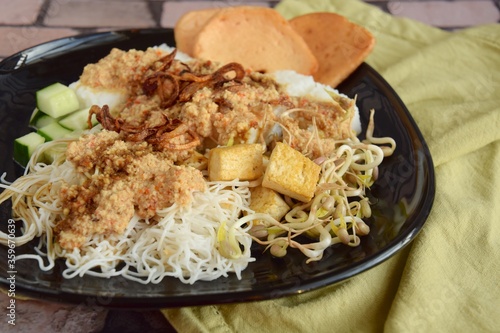 Ketoprak, vegetarian Indonesian food from Indonesia. consists of tofu, cucumber, rice cake, rice vermicelli and mung bean sprouts served with peanut sauce, soy sauce, kerupuk and fried shallot photo