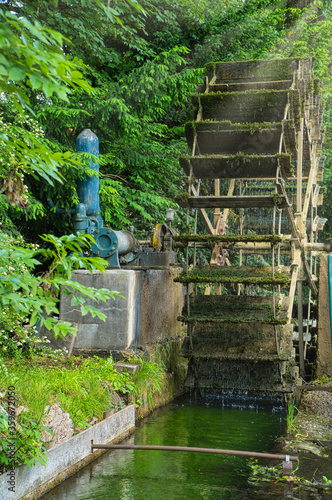 Altes funktionierendes Wasserrad mit Bachlauf