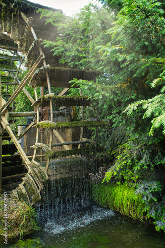 Altes funktionierendes Wasserrad mit Bachlauf