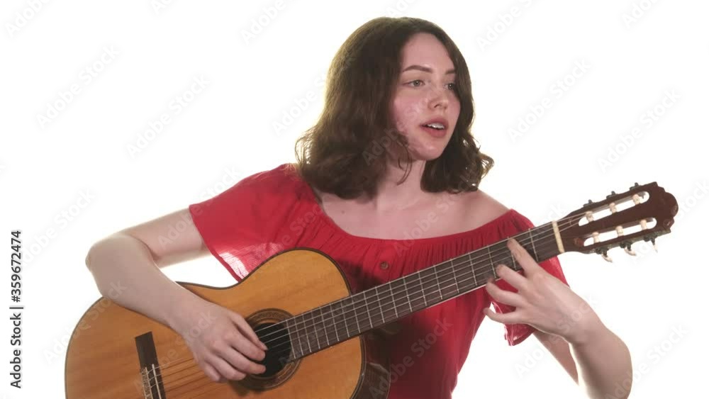Medium long shot of young talented woman playing the classical acoustic guitar. Isolated. Close up Medium long shot of young talented woman playing the classical acoustic guitar. Isolated. Close up