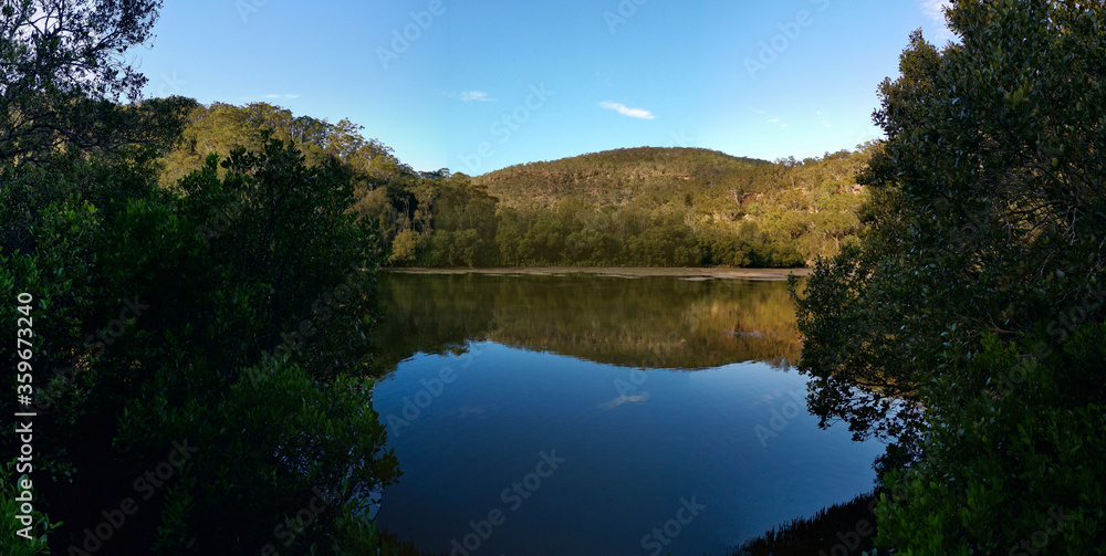 Creek with beautiful reflections of blue sky, mountains and trees, Crosslands Reserve, Berowra Valley National Park