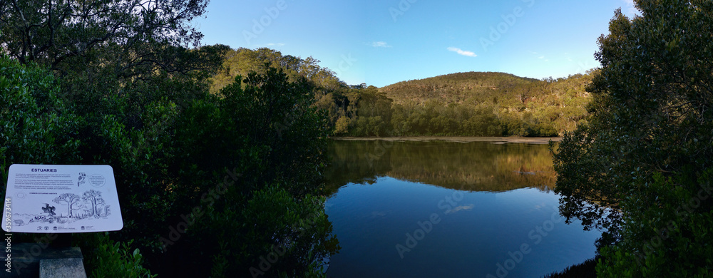 Panoramic view of creek with beautiful reflections of blue sky, mountains and trees, crosslands reserve, berowra valley national park