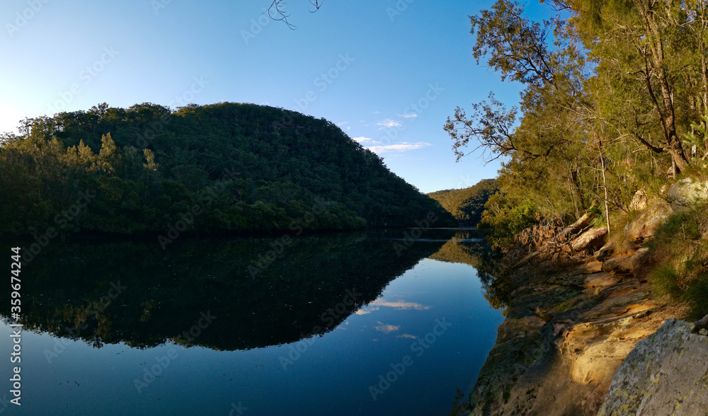Fototapeta premium Creek with beautiful reflections of blue sky, mountains and trees, Crosslands Reserve, Berowra Valley National Park