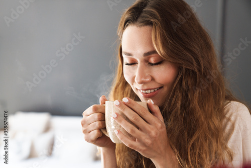 Lovely smiling young girl holding mug
