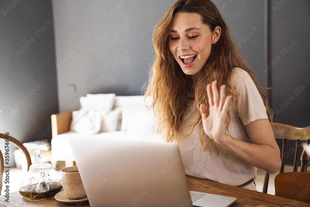 Lovely cheerful young girl sitting at the kitchen table Lovely cheerful young girl sitting at the kitchen table
