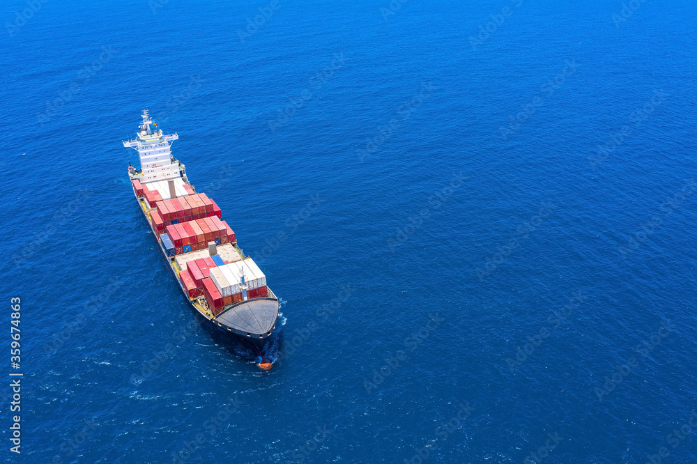 Large loaded container Ship cruising slowly at Sea, Aerial view.
